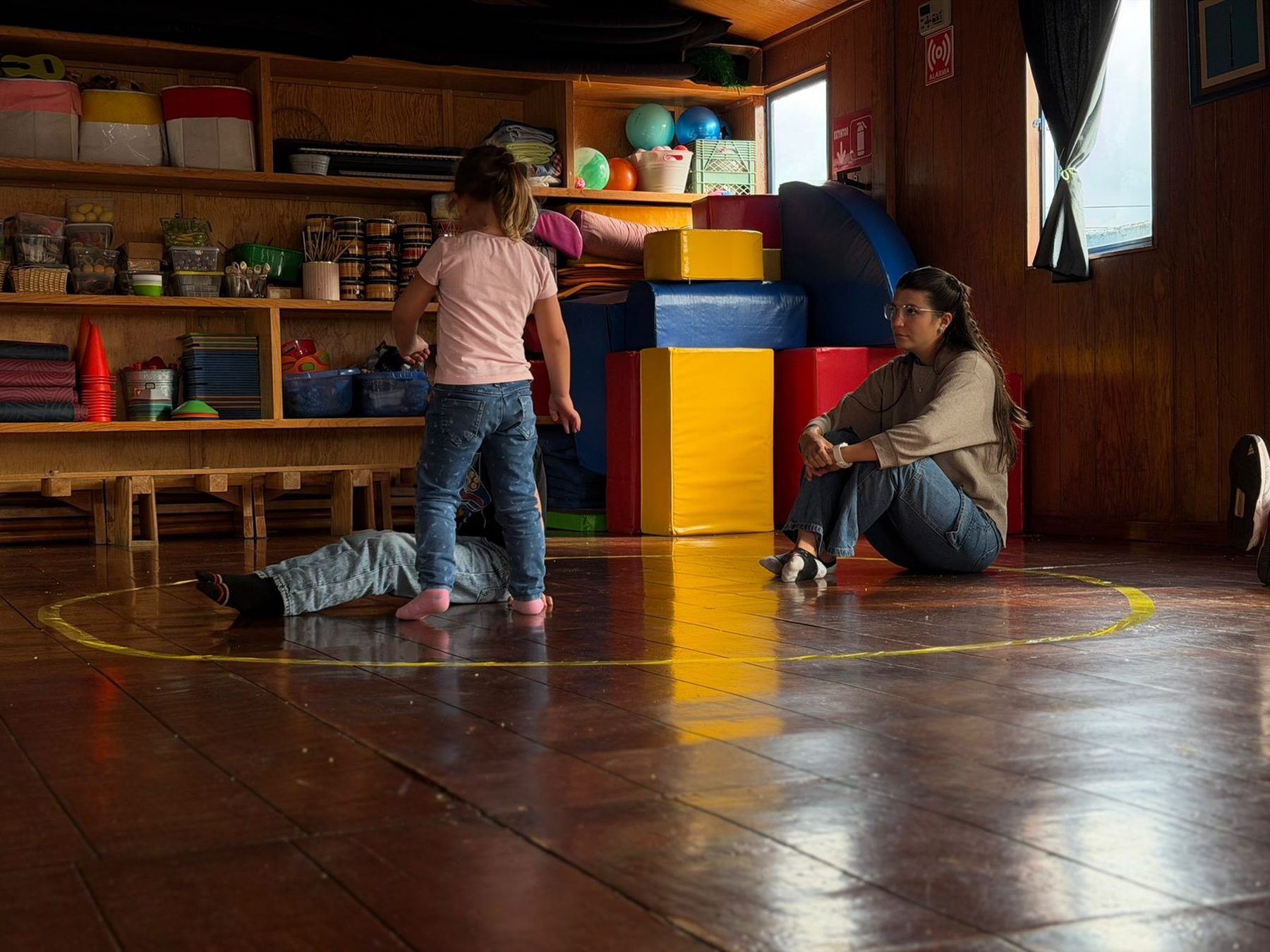 Psicóloga sentada con una niña dentro de un círculo del taller de Gestión Emocional de Tribu